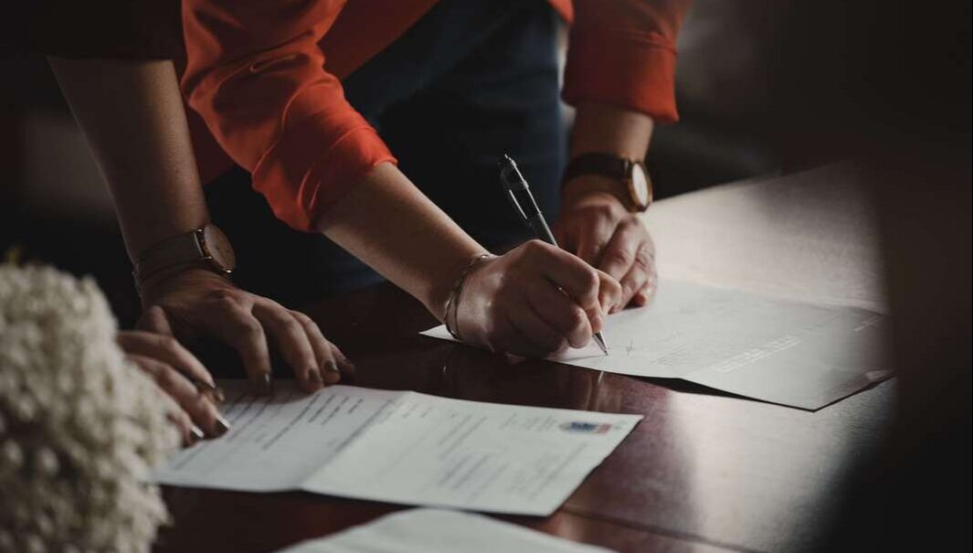 Employee signing an employment contract with a mandatory arbitration clause, employer and employee discussing sexual harassment in the workplace in fort worth, texas